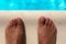 Barefoot on swimming pool background, top view