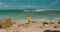 Barefoot tourist woman running to the ocean and enjoys coast sandy Green Bowl Beach in Bali Island Indonesia. Alone girl