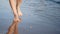 Barefoot travel sunny girl walking on sand beach with calmness sea wave enjoying summer vacation