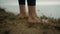 Barefoot unknown woman standing beach hill close up. Bare legs placed hilltop.