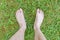 Barefoot walking. Feet of a man on green grass