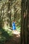 Barefoot woman dressed in blue walking alone through forest