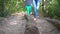 Barefoot woman leading her child boy through tree log on healthy sensory path