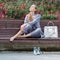 Barefoot woman sits on bench in park with eyes closed