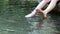 Barefooted boy cooling his feet in water with crystal clear water and idyllic floating creek in summertime shows outdoor hiking to