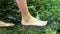 Barefooted boy cooling his feet in water with crystal clear water and idyllic floating creek in summertime shows outdoor hiking to