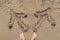 Barefooted female legs with two arrows drawn in the sand in different directions