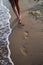 Barefooted female legs, walking along the strip of the sea. In move.