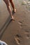 Barefooted female legs, walking along the strip of the sea on the sunset.