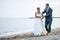 Barefooted newlywed couple walking on the beach