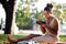 Barefooted woman sitting on grass and eating yummy salad