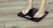 Barefooted woman is standing on scales weightning at home, feet closeup.