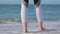 Barefooted woman walking on the beach, sea waves wash his feet