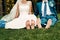 Barefooted young fair-haired bride and her fiance sits on the grass in an exotic park