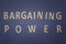 Bargaining Power written with wooden letters on a blue background