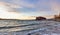 Barge container ship collided on a rocky coast during wind storm. Sunset Sky.