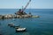 Barge with crane for dredging the seabed at the port of Riomaggiore, Cinque Terre, royalty free