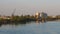 The barge departs from the river bank with an industrial zone. Water flow on the Sava river, Serbia, Sremska Mitrovica