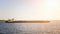 The barge floats along the river in the light of the setting sun