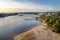 A barge flowing on the river Rhine in western Germany at sunset, the dried river bank visible.