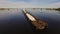 Barge loaded with sand and gravel floats on the wide river on the background of the bridge. Aerial view