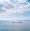 barge loaded with sand on the river. blue sky with clouds over river