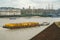 Barge pulling yellow containers on the River Thames at Greenwich