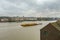 Barge pulling yellow containers on the River Thames and passing through Greenwich