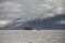 Barge towed by tugboat in coastal alaska clouds and mountainous background