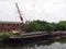 Barges and houseboats on the aire and calder navigation canal at stourton leeds with and old crane and the historic thwaite mills
