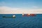Barges ship cargo containers in sea in Copenhagen, Denmark. Cargo ships float in blue sea on idyllic sky. Marine