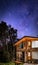 BARILOCHE, ARGENTINA, JUNE 19, 2019: Exterior of a wooden cozy and relaxing cabin in the forest with an amazing starred sky