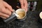 Barista adding milk to coffee at table