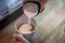 Barista in cafe or coffee bar preparing proper cappuccino pouring milk froth in a cup. Waiter hands pouring milk making cappuccino