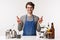 Barista, cafe worker and bartender concept. Portrait of hopeful smiling cute male employee in apron, making coffee or