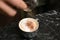 Barista decorating coffee with cinnamon at table