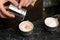 Barista decorating coffee with cinnamon at table