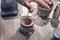 Barista doing french press with a bucket of coffee beans.