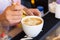Barista girl makes latte art in a coffee shop
