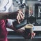 Barista girl pouring milk into coffee. Process of making cappuccino or latte