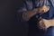 Barista grinds coffee beans in a manual coffee grinder. Dark background. Low key