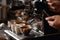Barista hand and espresso pouring in a cup in a cafe shop. Coffee maker machine closeup, professional portafilter. Generative AI