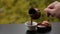 Barista hand pouring tasty hot coffee in cup brewed in traditional turkish pot, cafe table outdoors