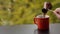 Barista hand pouring tasty hot coffee in red cup brewed in traditional turkish pot, cafe table outdoors