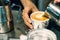 Barista hands pouring hot milk on a cup to make latte art