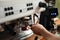 Barista inserting portafilter into coffee machine indoors