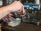 Barista makes coffee, close up, on the background of the coffee machine with soft focus. The hands of the bartender