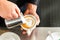 Barista making cappuccino in his coffeeshop