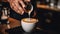 Barista male hands pouring milk and preparing fresh cappuccino