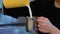 Barista pour milk into milk pitcher in slow motion